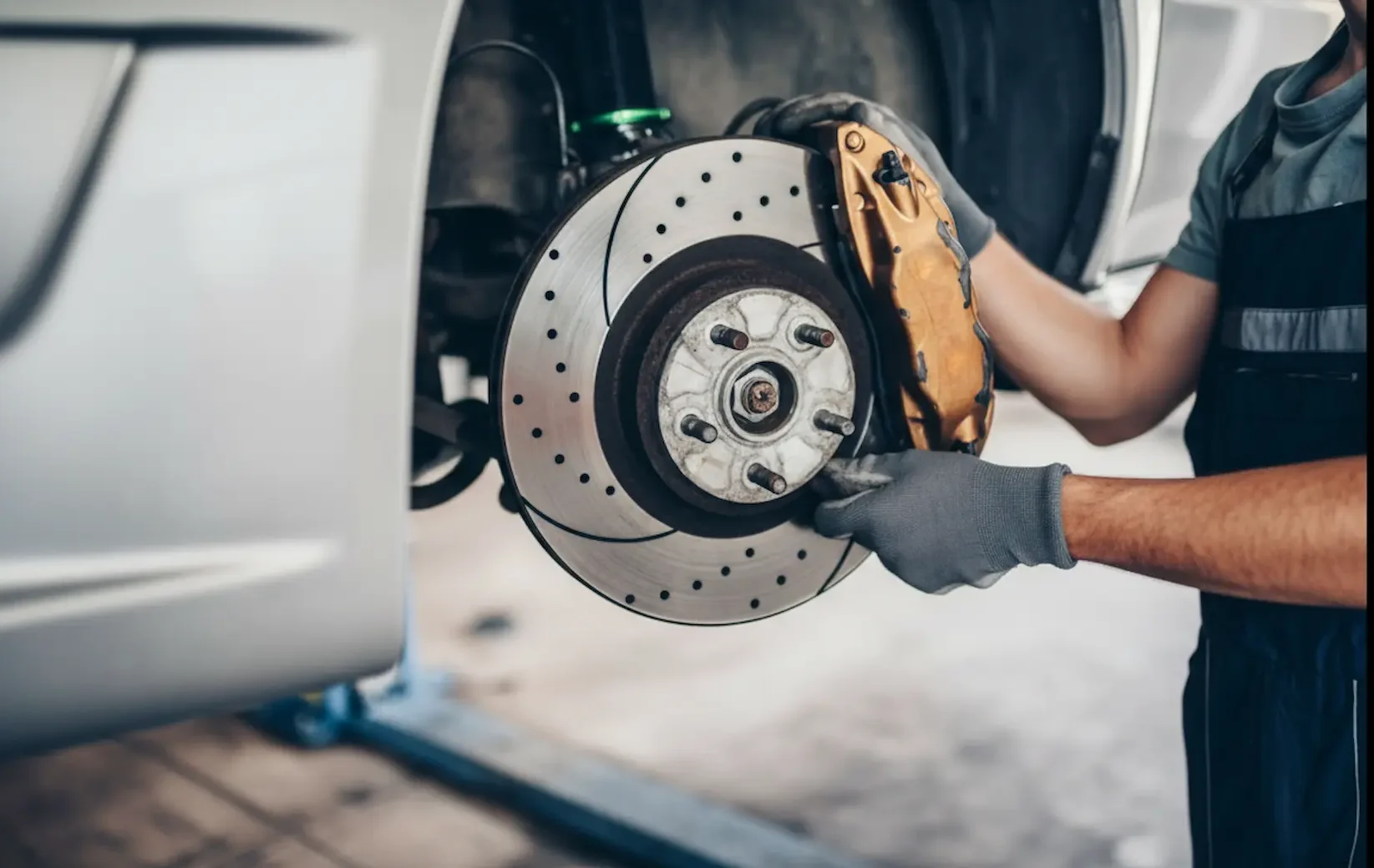 Mechanic at Southport Auto Repair car parts carefully installing performance brake rotors for enhanced safety.