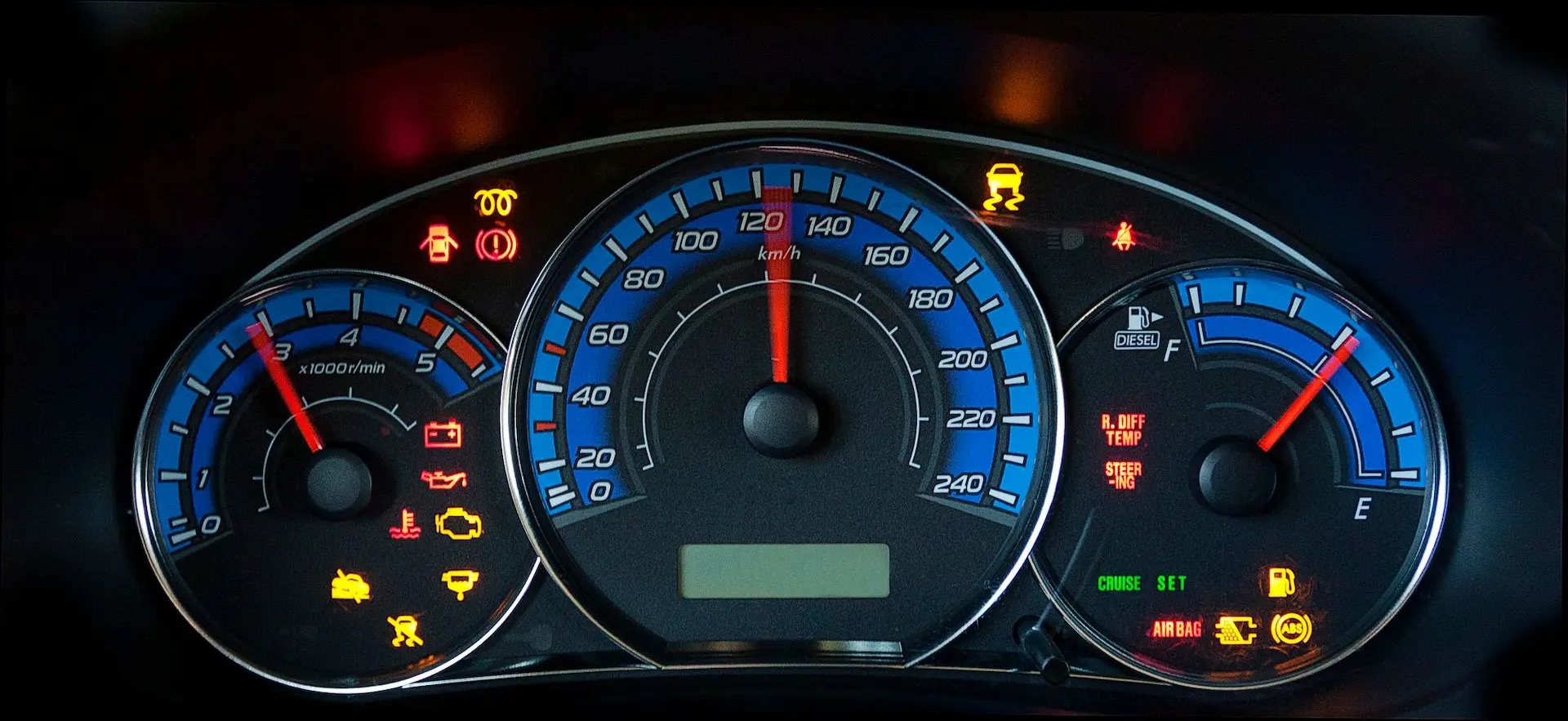 Engine light: Wide view of a blue-backlit dashboard with multiple gauges and warning Engine lights for oil, battery, temperature, and tire pressure.