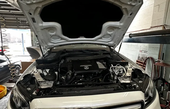 Mercedes Benz engine bay inspection with hood open during maintenance service