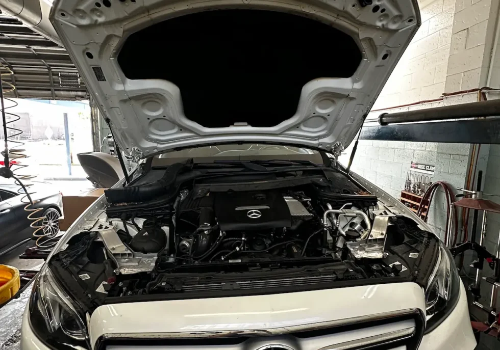 Mercedes Benz engine bay inspection with hood open during maintenance service
