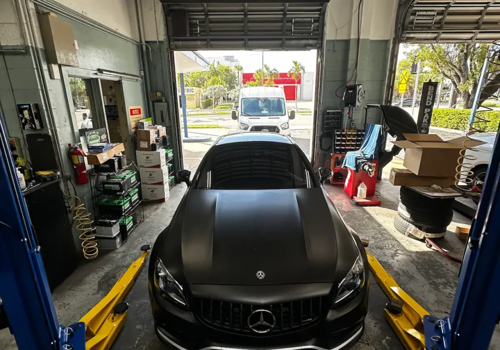 Matte black Mercedes-Benz repair service AMG inside Southport auto repair garage during mechanical inspection