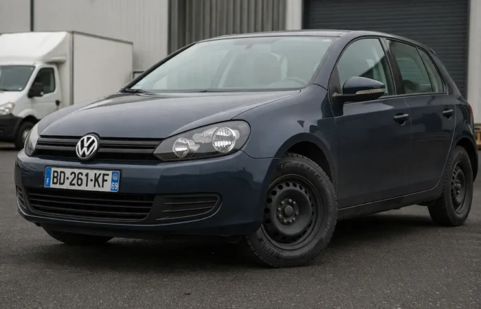 European Volkswagen car fitted with a durable commercial tire, parked in an industrial setting with reinforced tread visible.