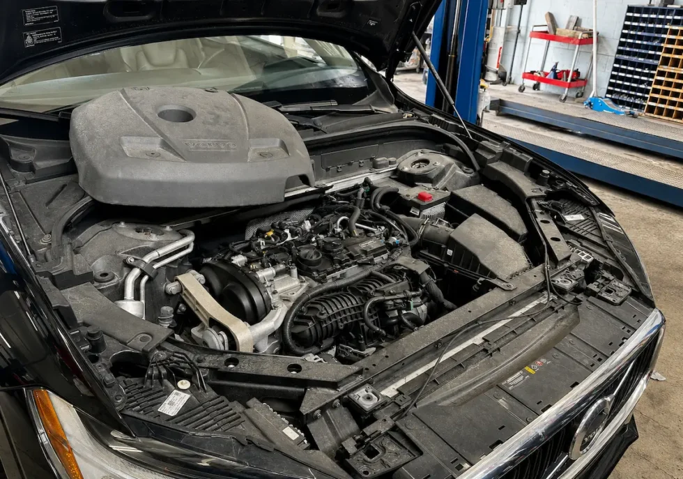 Volvo repair Fort Lauderdale service center showing an open Volvo engine bay during professional engine diagnostics, maintenance inspection, and repair work in an automotive workshop.