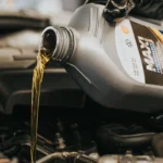 Fresh motor oil being poured into an engine during an oil change at Southport Auto Repair in Fort Lauderdale