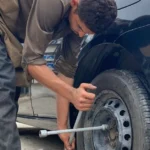 Technician changing a tire with a lug wrench at Southport Auto Repair in Fort Lauderdale